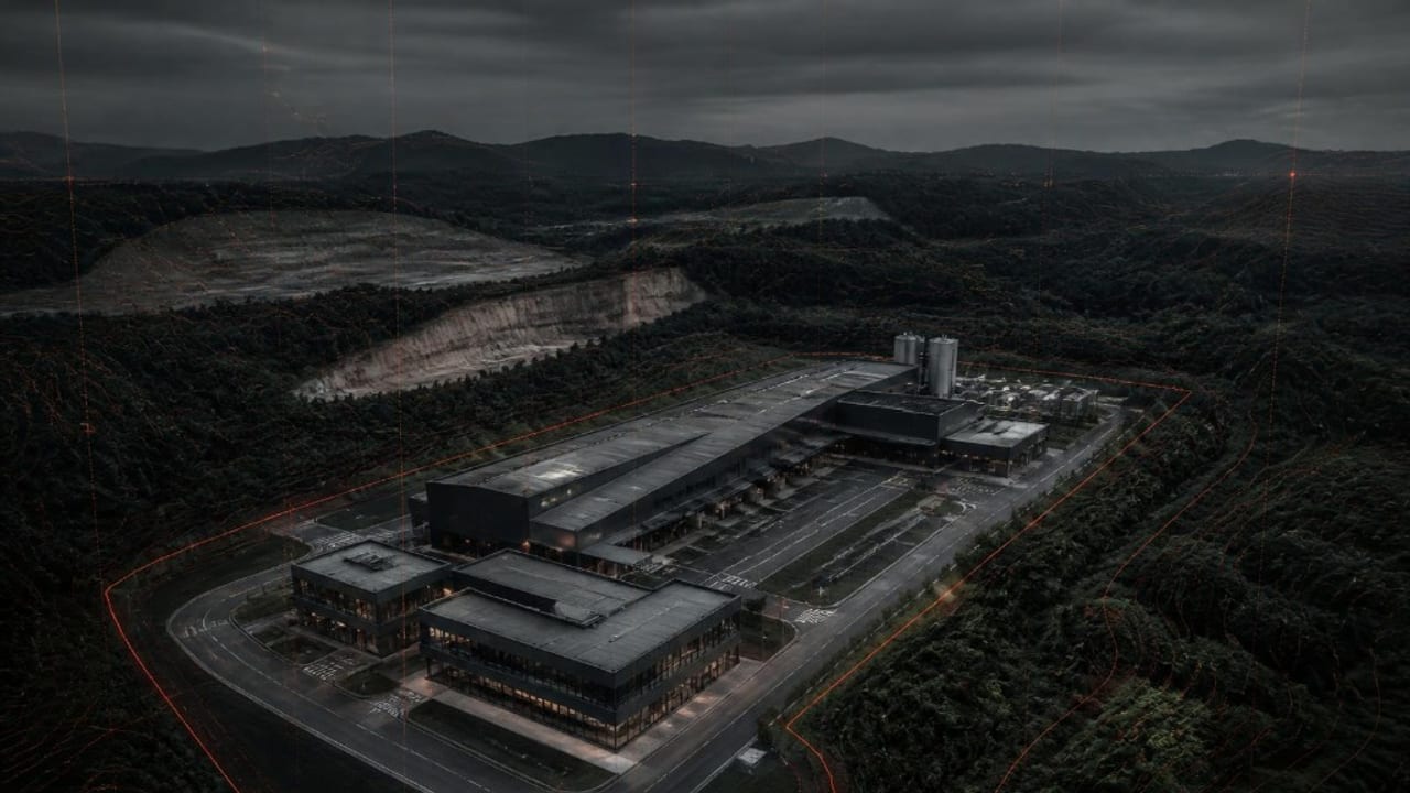 Vista aérea de planta industrial moderna iluminada à noite com demarcações técnicas de zoneamento para licenciamento ambiental em Londrina.
